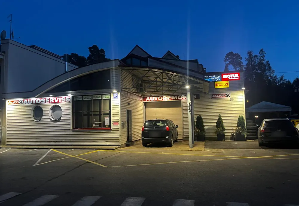Auto klubs SC ēka vakarā, skats no stāvvietas